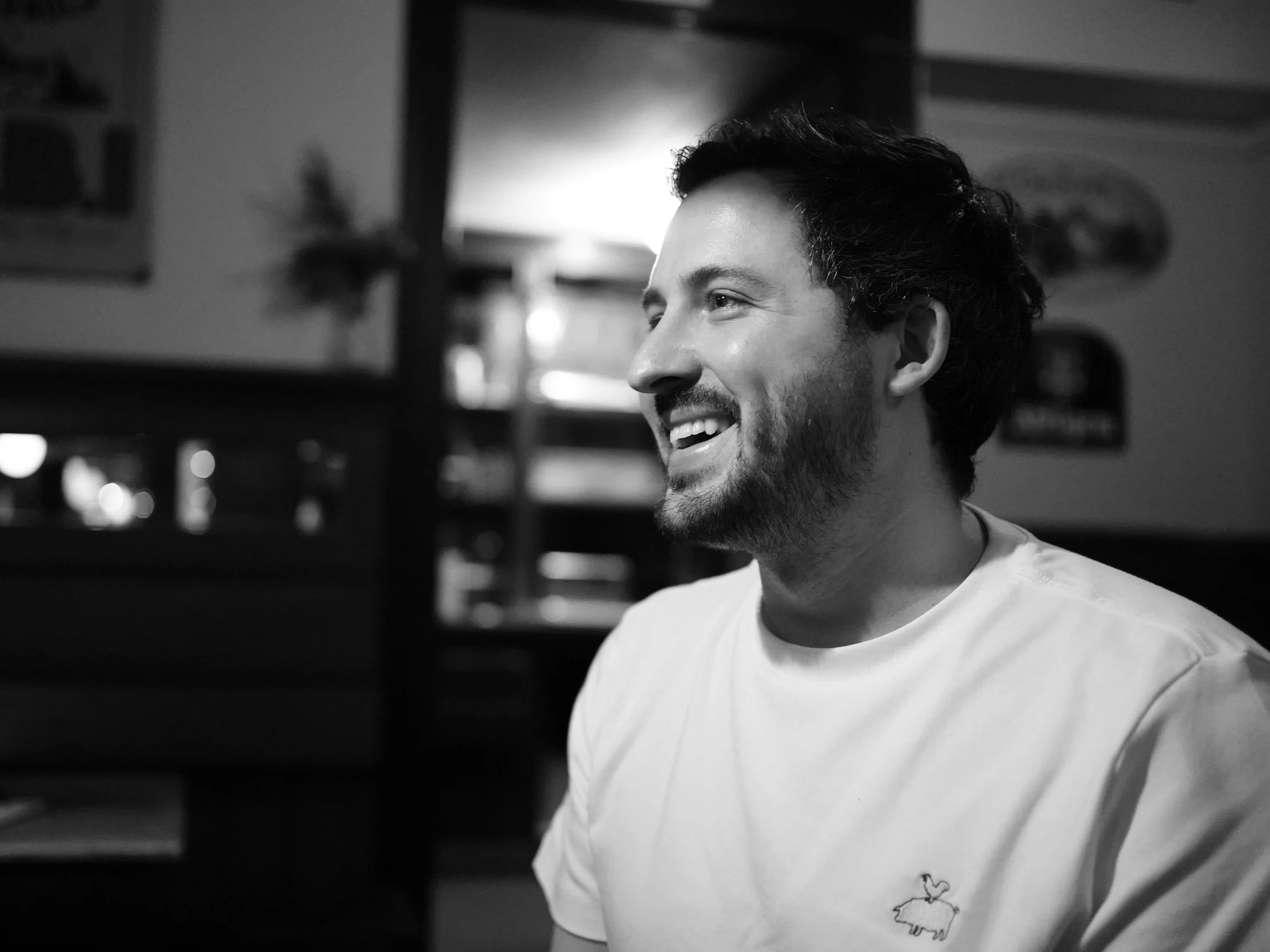 Portrait of Ismaël Auray, smiling, in a softly lit interior.